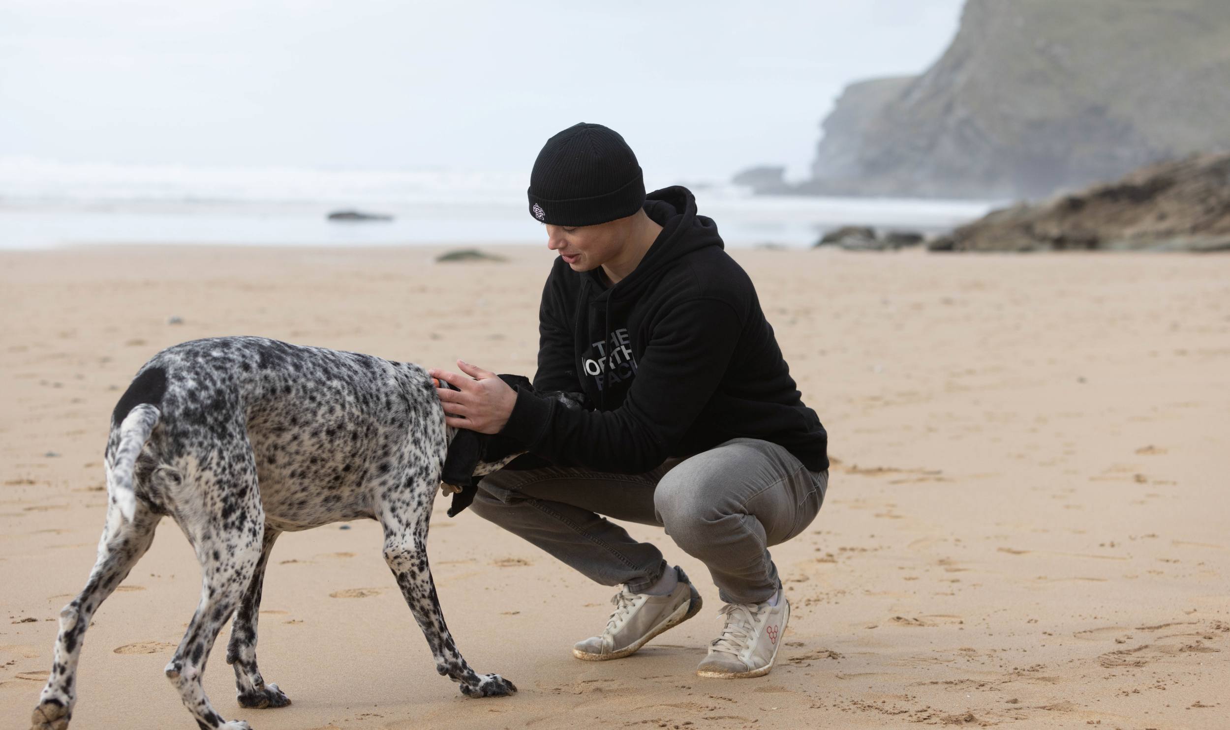 black organic cotton beanie walking dog on beach